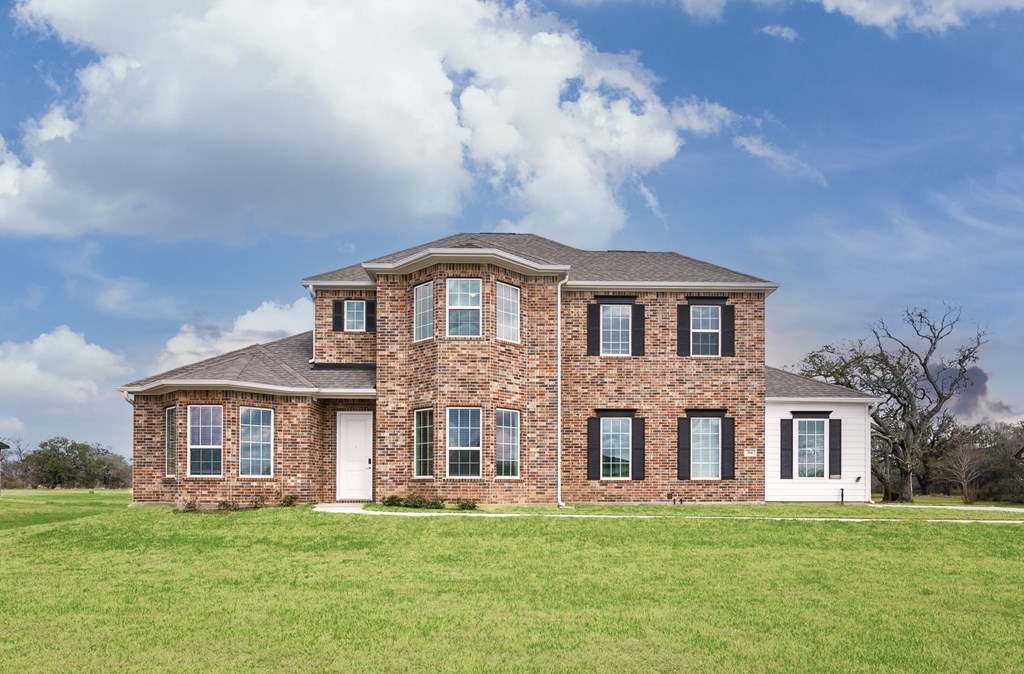 a brick house on a hill with a cloudy blue sky
